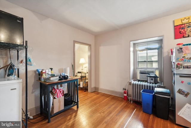 interior space featuring hardwood / wood-style flooring, cooling unit, and radiator heating unit