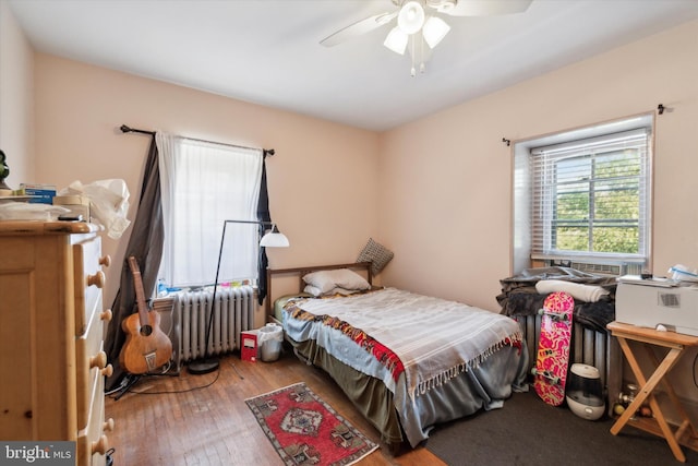 bedroom featuring radiator heating unit, hardwood / wood-style flooring, and ceiling fan