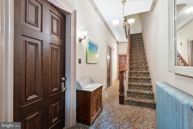 foyer featuring crown molding, radiator, and an inviting chandelier