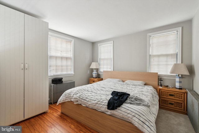 bedroom featuring light wood-type flooring and radiator