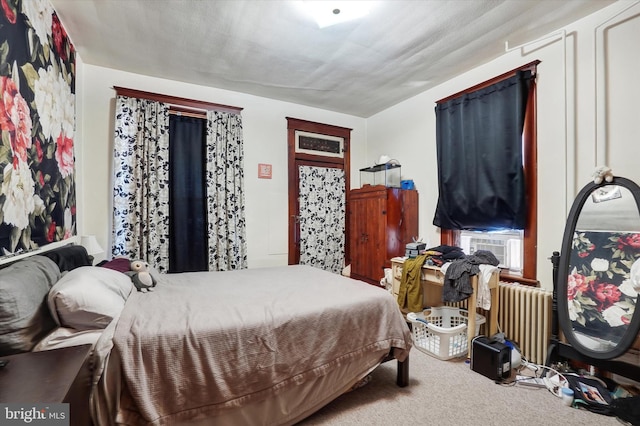 bedroom with carpet flooring, radiator, and cooling unit