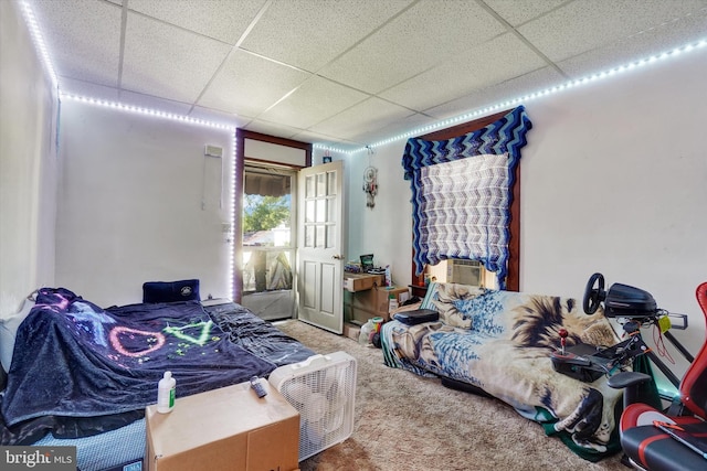 bedroom with carpet flooring, a drop ceiling, and cooling unit