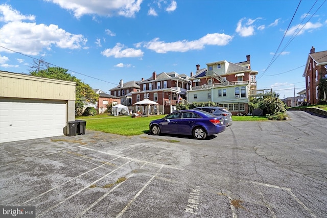 view of vehicle parking with a garage and a lawn