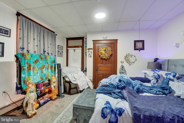 carpeted bedroom featuring a paneled ceiling and baseboard heating