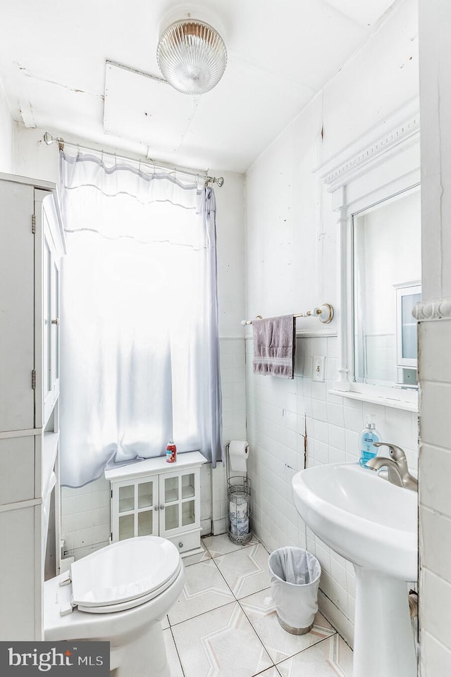 bathroom with curtained shower, tile walls, and toilet