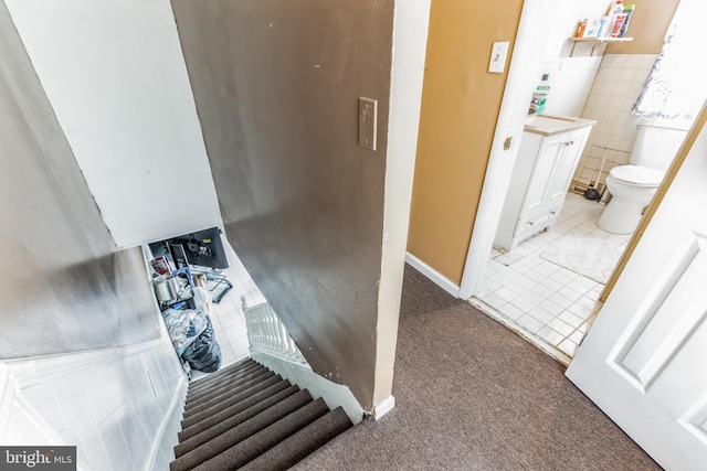 stairs with tile walls and carpet