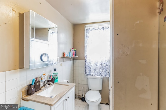 bathroom with tile walls, vanity, and toilet