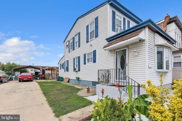 view of front of property featuring a front lawn and a carport