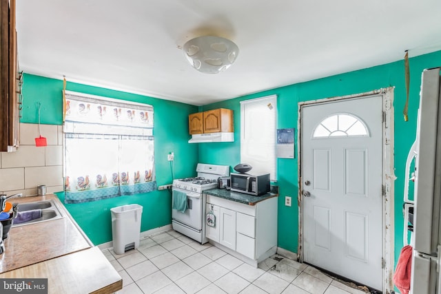 kitchen featuring light tile patterned floors, sink, and white appliances