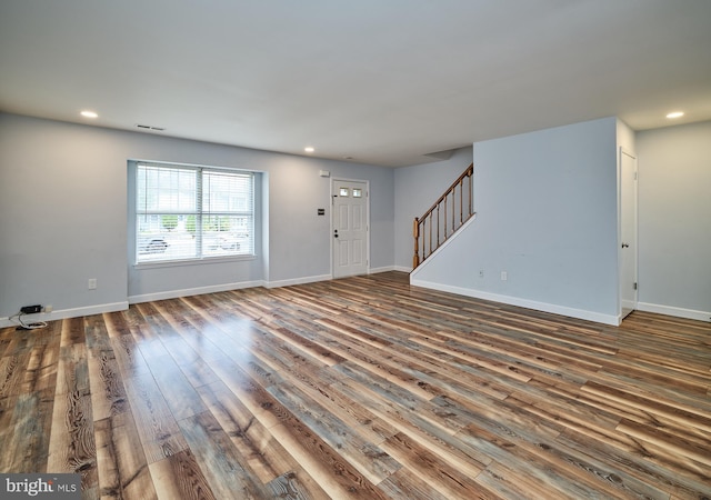 unfurnished living room featuring dark wood-type flooring