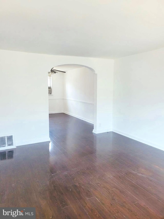 unfurnished room featuring cooling unit and dark hardwood / wood-style flooring