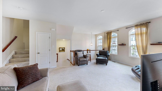 carpeted living room featuring an inviting chandelier