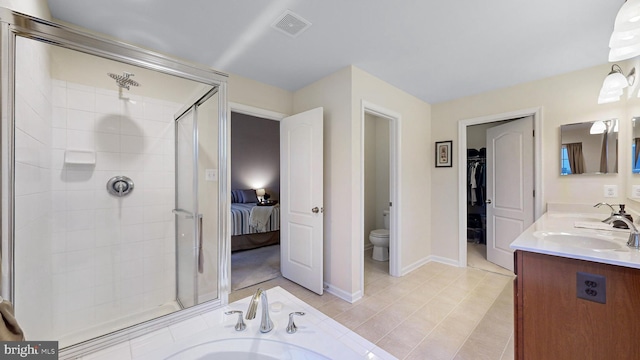 bathroom with tile patterned flooring, vanity, toilet, and a shower with shower door