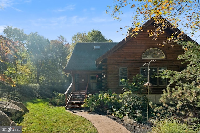 log cabin with a front lawn