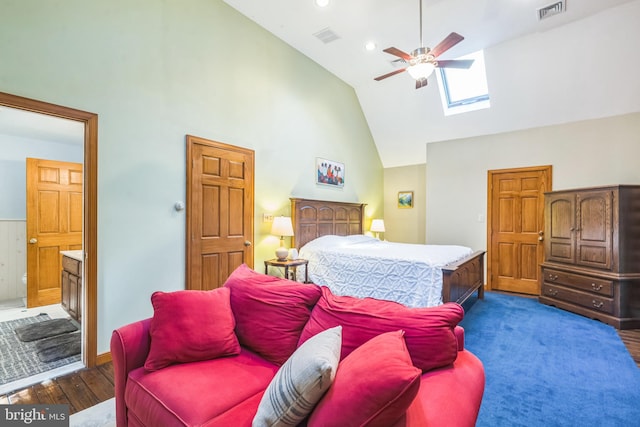 bedroom with high vaulted ceiling, ceiling fan, dark hardwood / wood-style floors, connected bathroom, and a skylight