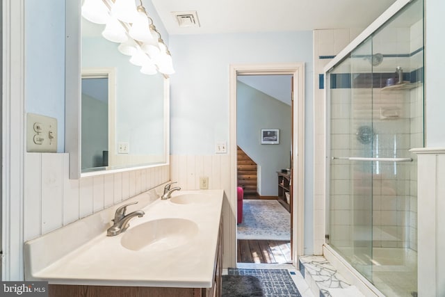 bathroom with walk in shower, vanity, and wood-type flooring