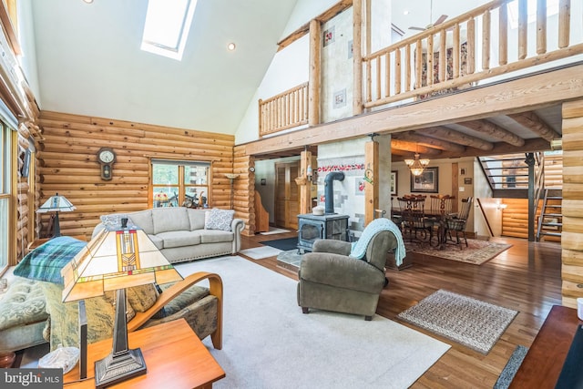 living room featuring beamed ceiling, a wood stove, wood-type flooring, high vaulted ceiling, and log walls