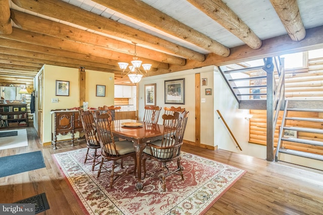 dining space featuring an inviting chandelier, beamed ceiling, and hardwood / wood-style floors