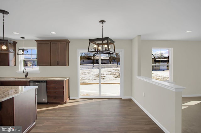 kitchen featuring stainless steel dishwasher, dark hardwood / wood-style floors, sink, and hanging light fixtures