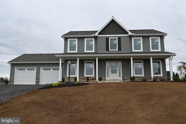 view of front of house with a porch, a garage, and a front lawn