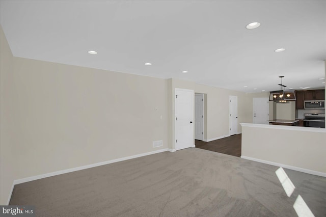 unfurnished living room featuring dark colored carpet