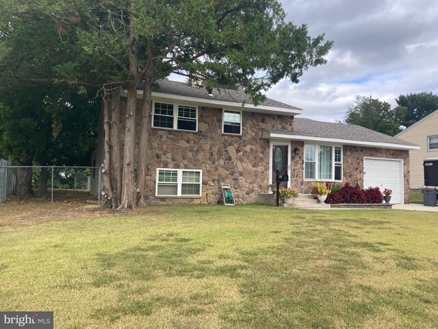 tri-level home with a garage and a front yard