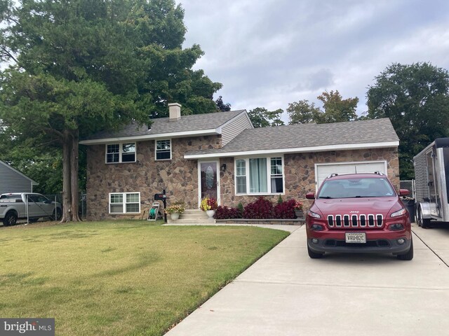 split level home with a front yard and a garage