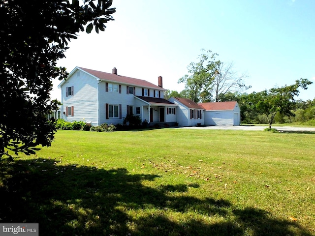 colonial house featuring a garage and a front lawn