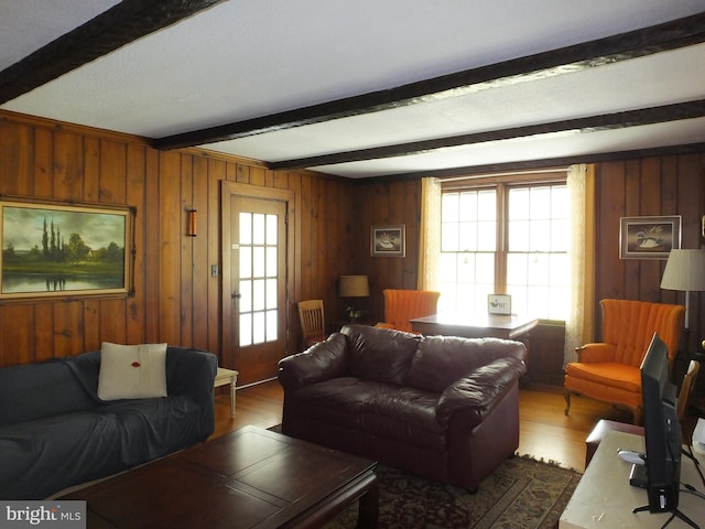 living area featuring wood finished floors, wood walls, and beam ceiling