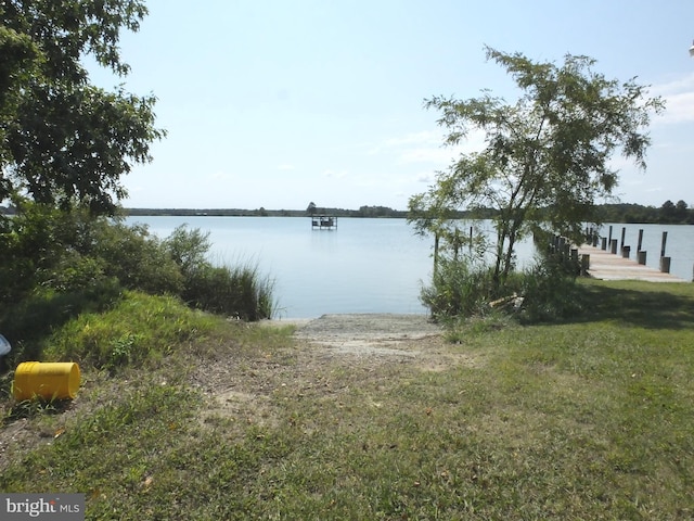 dock area with a lawn and a water view