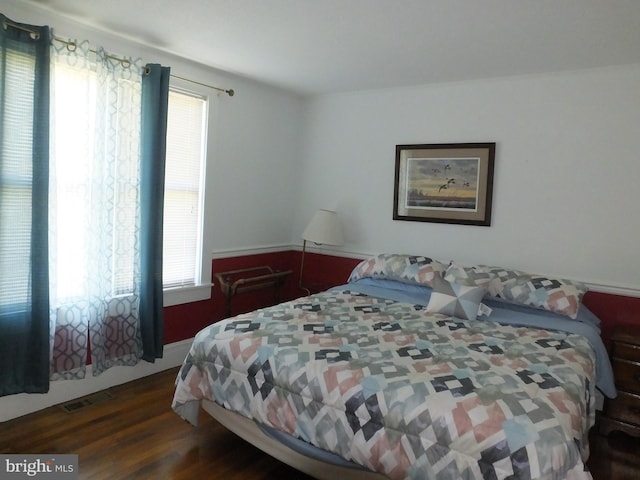 bedroom with visible vents and wood finished floors