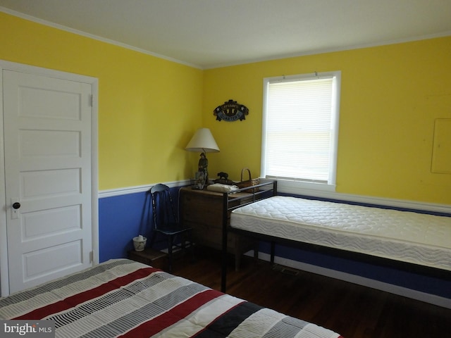 bedroom with crown molding and dark hardwood / wood-style flooring