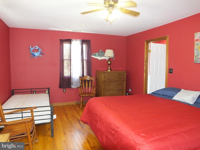 bedroom featuring visible vents, baseboards, and wood finished floors