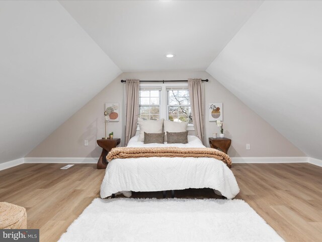 bedroom featuring lofted ceiling and hardwood / wood-style floors