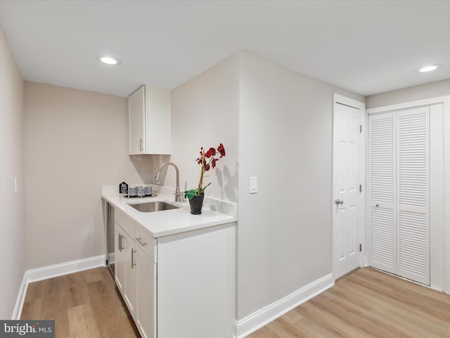 kitchen featuring sink, white cabinetry, and light hardwood / wood-style floors