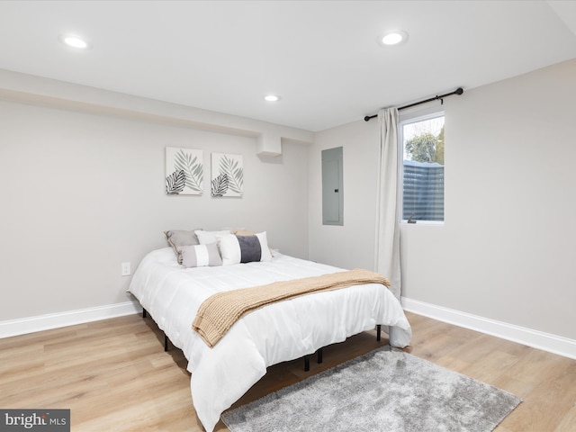 bedroom featuring electric panel and hardwood / wood-style floors