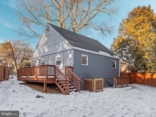 snow covered house featuring a deck