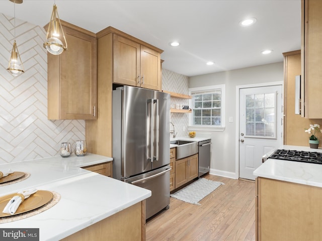 kitchen with light stone counters, stainless steel appliances, decorative backsplash, and hanging light fixtures