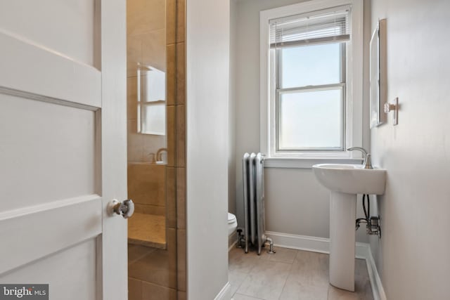 bathroom with radiator heating unit, tile patterned flooring, and toilet