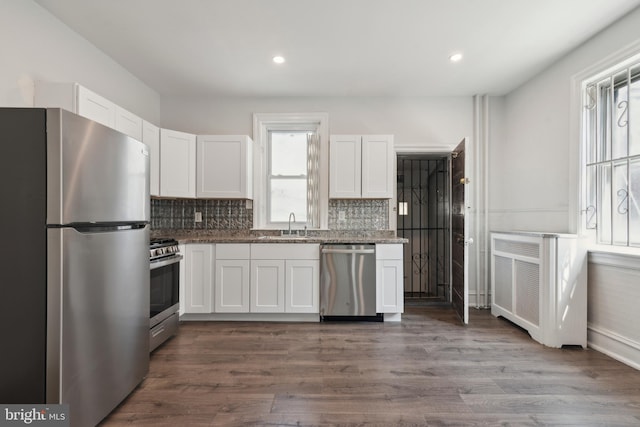 kitchen with stainless steel appliances, white cabinets, and a wealth of natural light