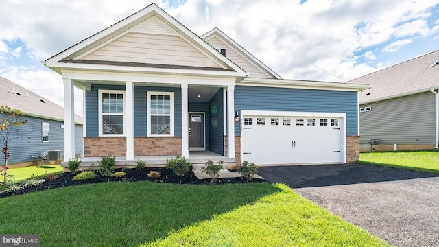 view of front of home with central AC, a front lawn, a porch, and a garage