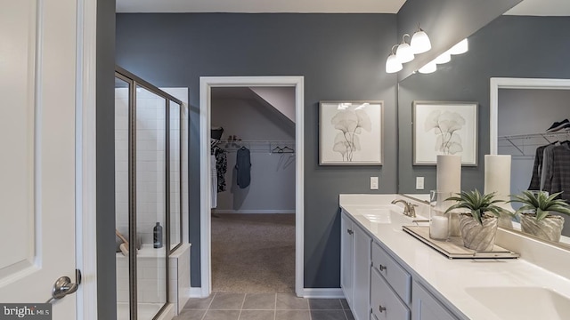 bathroom with walk in shower, vanity, and tile patterned flooring