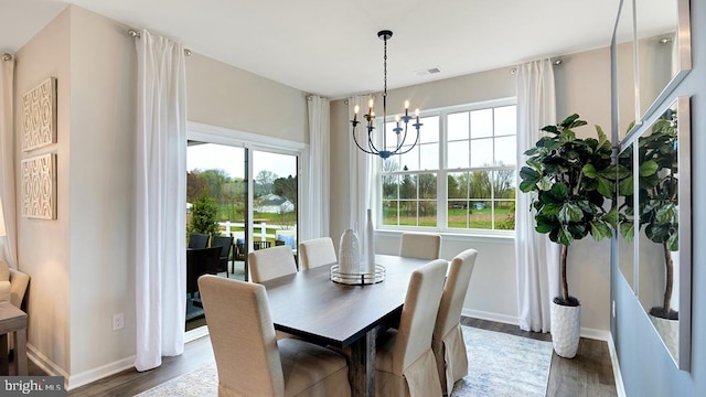 dining space featuring dark hardwood / wood-style floors and a chandelier