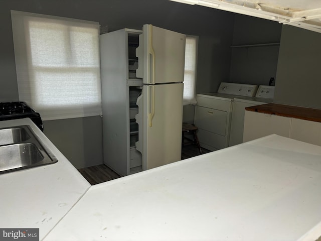 kitchen featuring sink, independent washer and dryer, and white fridge