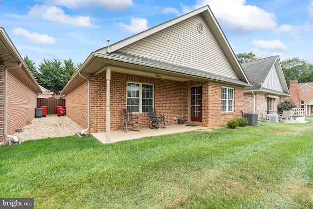 rear view of house featuring a yard, central air condition unit, and a patio area