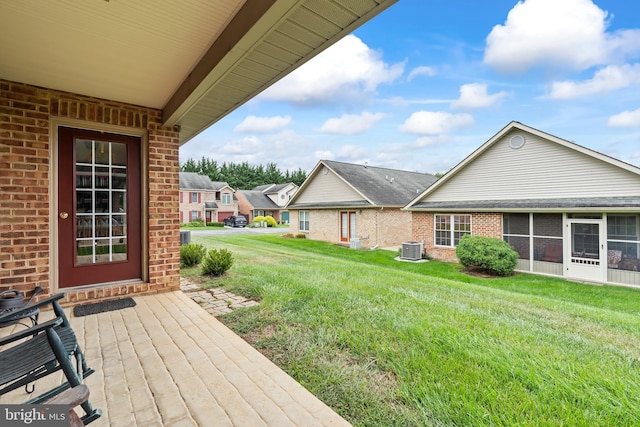 view of yard featuring a sunroom and central AC unit