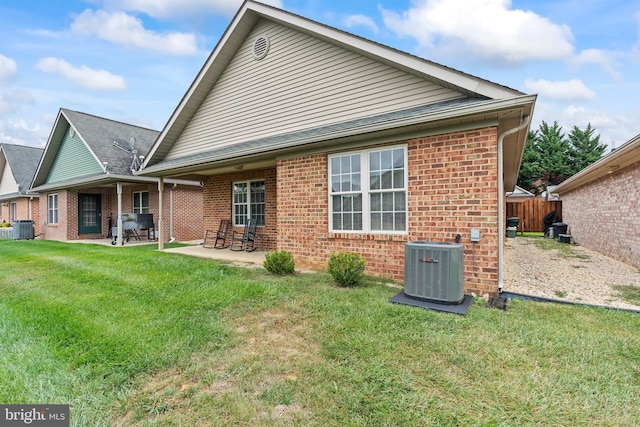 back of house with central AC unit, a yard, and a patio area