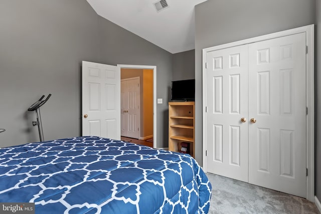 carpeted bedroom with vaulted ceiling and a closet