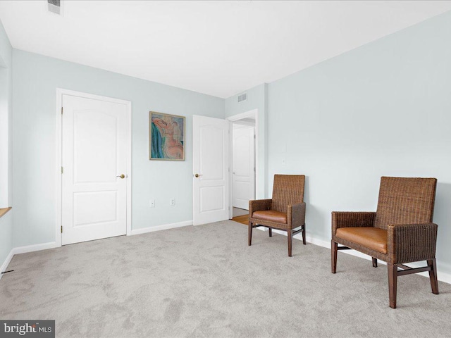 sitting room featuring light colored carpet