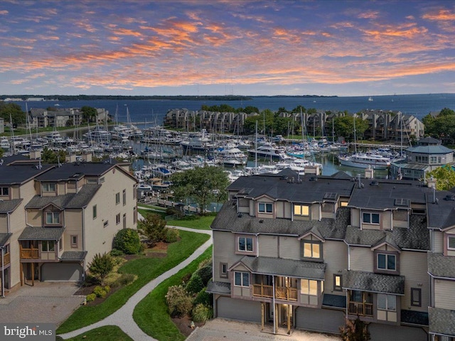 aerial view at dusk featuring a water view